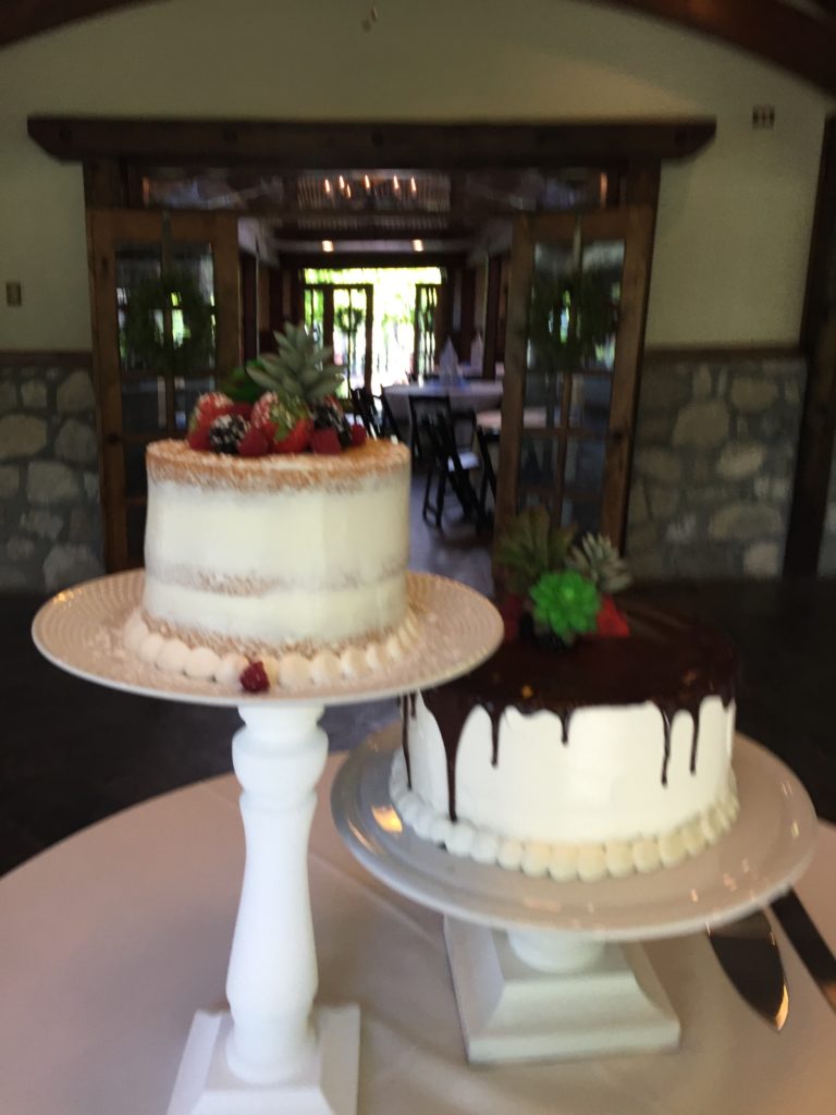 Wedding cake display with two cakes, buttercream frosting and decorated with fresh fruit